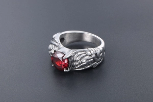 Close-up of vintage wing ring with large red gemstone and detailed silver carvings