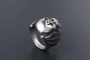 Detailed close-up of retro stainless steel bat and skull ring with gothic engravings