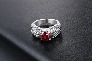 Macro shot of silver eagle wing ring featuring a large faceted red gemstone inlay