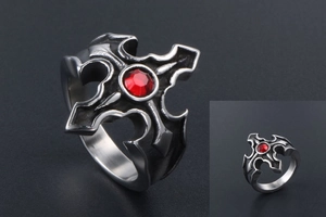 Détail macro de bague gothique avec croix et strass rouge en acier inoxydable vintage