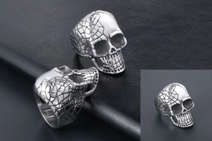 Macro view showing vintage punk skull rings with detailed gothic carvings in silver steel