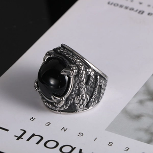 Macro detail of gothic claw ring featuring dragon scales and a polished black stone