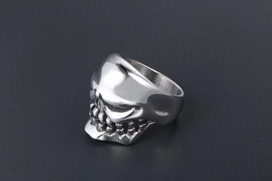 Macro side view of polished stainless steel skull ring with detailed gothic tooth engraving