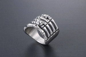 Detailed view of punk style stainless steel ring featuring a gothic skull bone hand