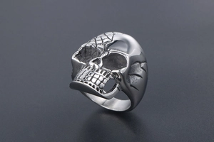 Macro detail of gothic skull ring in silver-tone titanium steel with engraved textures