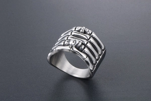 Macro shot of gothic punk skeleton hand ring with vintage silver skull relief details