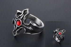 Gros plan d'une bague gothique en acier vintage avec un détail de pierre rouge