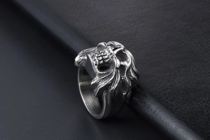 Detailed view of punk skull ring with intricate feather texture on polished steel