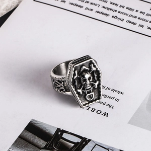 Close-up of vintage steel coffin ring with skull and DIE engraving in punk style