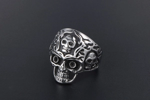 Makroaufnahme von Vintage-Totenkopfring mit filigranen silbernen Blumenrelief-Details