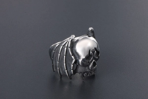 Macro detail of gothic skull ring with intricate bat wing carvings in vintage steel