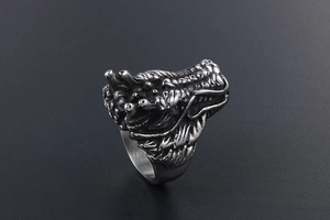 Detailed close-up of a vintage punk dragon head ring with intricate scales and antique finish