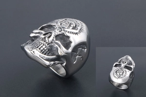 Macro detail of punk skull ring with sunburst carvings on polished titanium steel surface