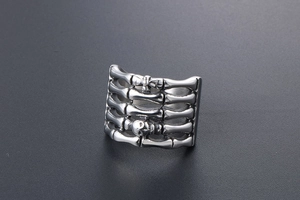 Macro detail of gothic titanium steel ring featuring silver rib bones and skull motif