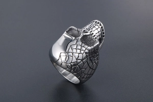 Detailed close-up of a vintage punk skull ring with textured scale-pattern detailing