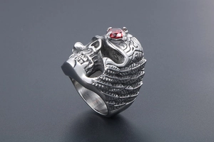 Detailed macro view of punk skull ring with red ruby stone and wing engraving