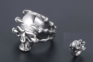 Detailed relief of a punk skull ring in silver-toned titanium steel with gothic motifs