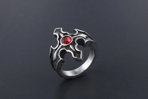 Macro d'une bague croix gothique en argent vintage avec une pierre rouge facettée