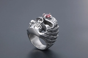 Macro detail of gothic skull ring with red gemstone and intricate silver carving