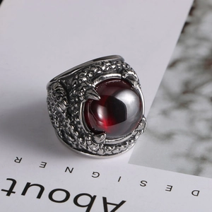 Macro shot of silver dragon claw ring featuring a large polished deep red zircon stone