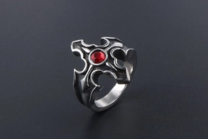 Détail macro de la bague gothique en acier titane avec gemme rouge et croix