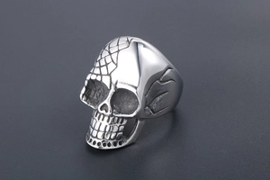 Detail of punk skull ring with unique mesh texture and flame engraving on silver steel