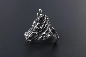 Detailed close-up of a vintage silver dragon head ring with intricate scales and carvings