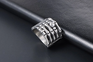 Macro shot of gothic skeleton claw ring in vintage titanium steel on black leather