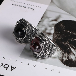 Detail of vintage punk rings featuring dragon claw textures and red black zircons