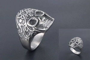 Detailed macro view of vintage skull ring featuring intricate floral engravings on silver metal
