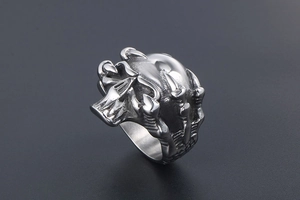 Detailed close-up of a punk skull ring with intricate dragon claw bone carvings on steel
