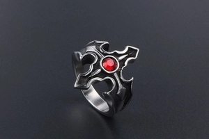 Détail d'une bague gothique punk avec cristal rouge central et motif de croix noire vintage