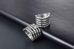 Detail shot of punk skeleton hand ring in titanium steel with skull relief on dark leather