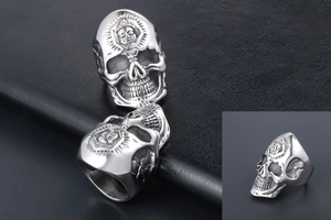 Detailed close-up of punk skull ring with intricate sunburst mask carving on titanium steel