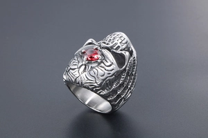 Detailed relief of gothic skull ring with central red stone and vintage steel finish
