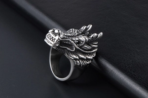 Detailed close-up of a vintage dragon head ring made of silver titanium steel on black leather