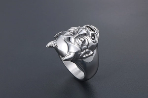 Dettaglio macro di un anello maschera di demone gotico in acciaio inox argento vintage
