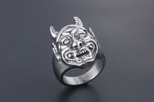 Dettaglio dell'anello punk con maschera di demone toro e incisioni metalliche fini