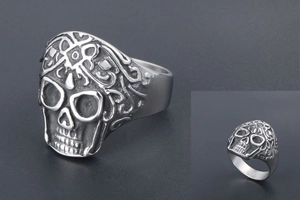 Macro detail of punk skull ring with intricate vine carvings and vintage steel finish