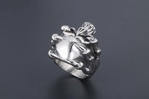 Macro detail of punk style beetle silver steel ring with intricate carving on dark background