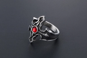 Bague gothique argentée avec pierre rouge et motifs de croix vue sous un angle de 45°