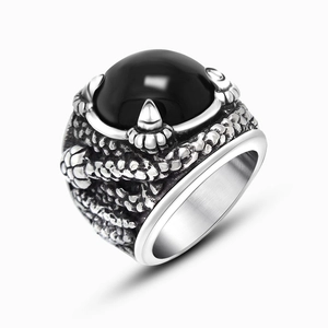 Macro detail of men's vintage dragon claw ring with a large black round gemstone