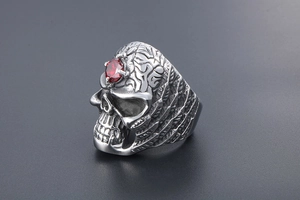 Macro shot of gothic titanium steel ring featuring red gemstone and skull detail
