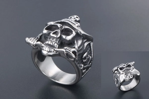 Detail view of gothic pirate skull ring with crossbones and swords in silver steel