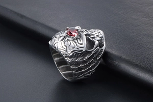 Detailed side view of Gothic skull ring with red faceted gemstone in vintage steel finish