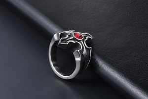 Vue détaillée d'une bague vintage en acier titane avec cristal rouge et croix gothique