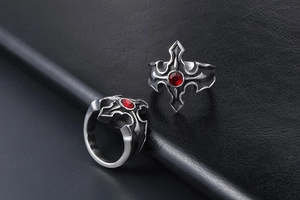 Gros plan d'une bague croix gothique en argent vieilli avec un strass rouge central