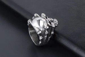 Macro shot of silver punk dragon claw ring with bone texture on black leather