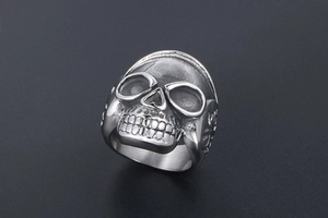 Detailed macro view of a vintage silver skull ring with gothic embossed metal patterns