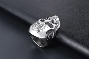 Macro shot of punk skull ring with sun and moon emblem on dark leather background